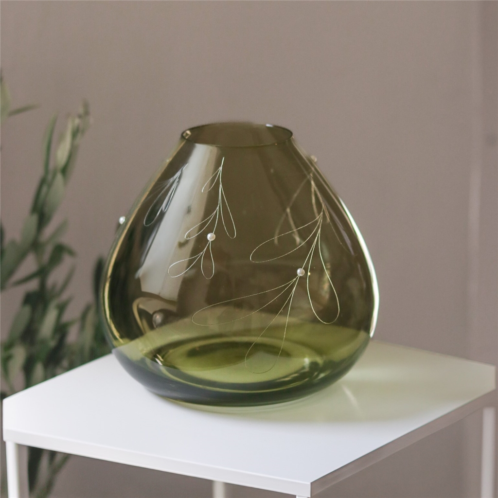Green glass vase with mistletoe decor