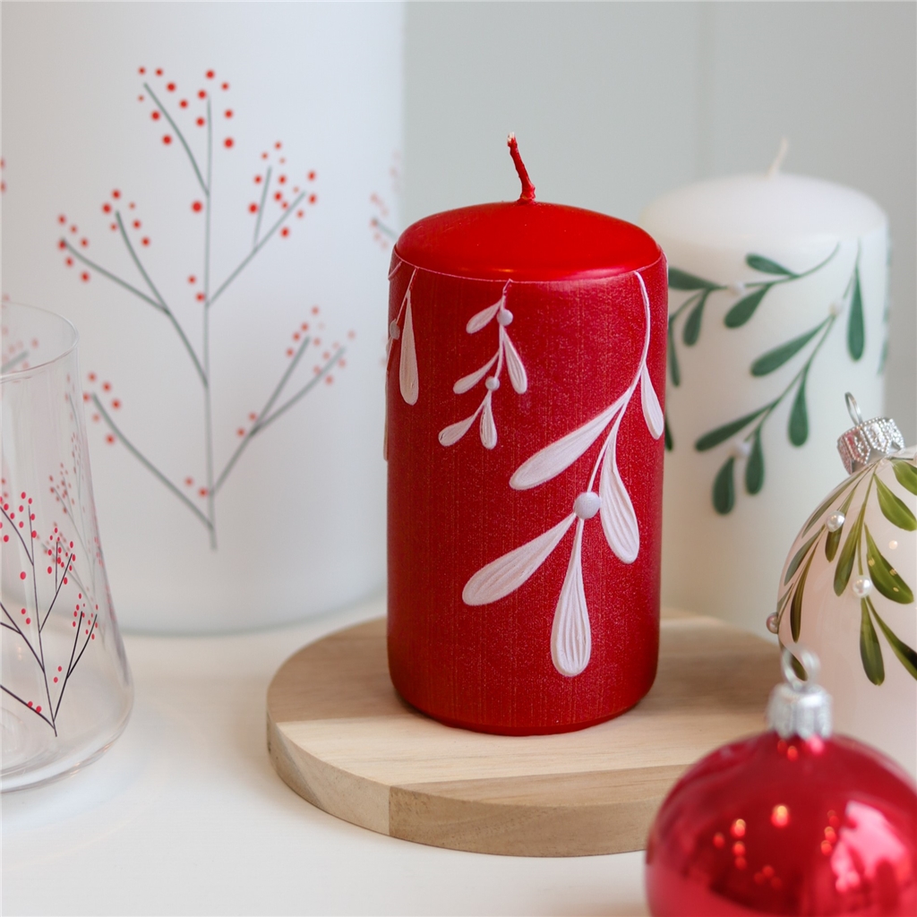 Red candle with mistletoe decor