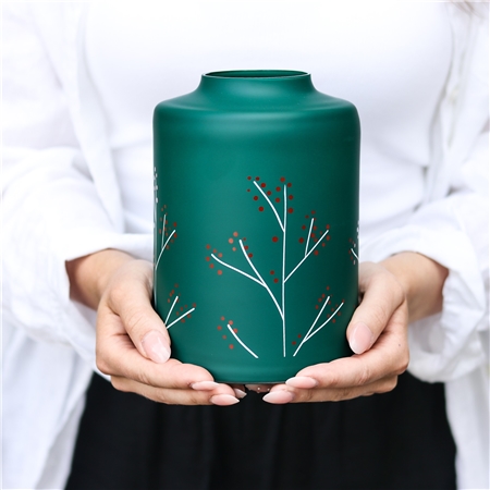 Green glass vase with holly decoration