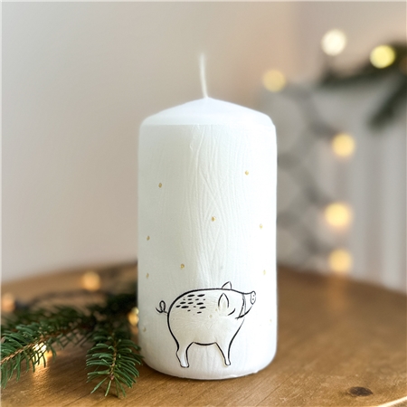 White candle with wild boar decor