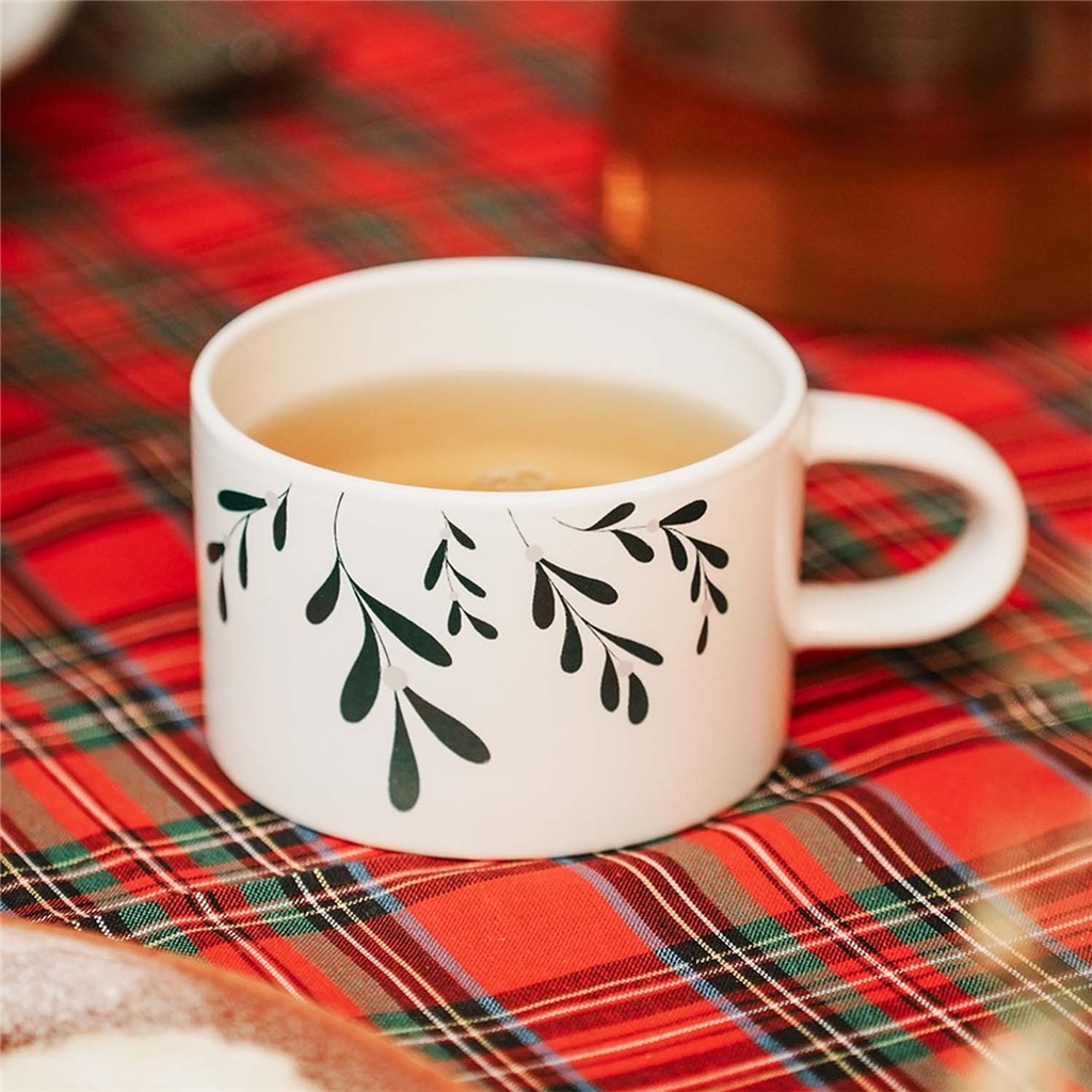 White mug with mistletoe decoration